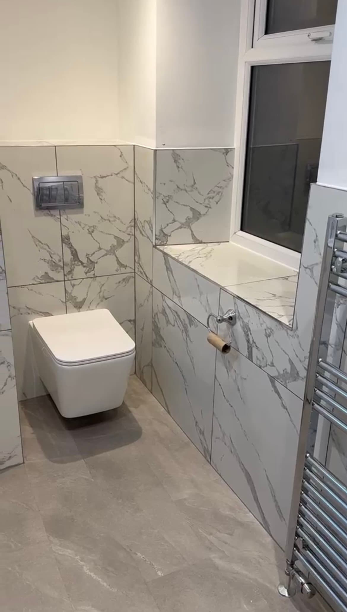 Wall-hung toilet in a marble-tiled bathroom