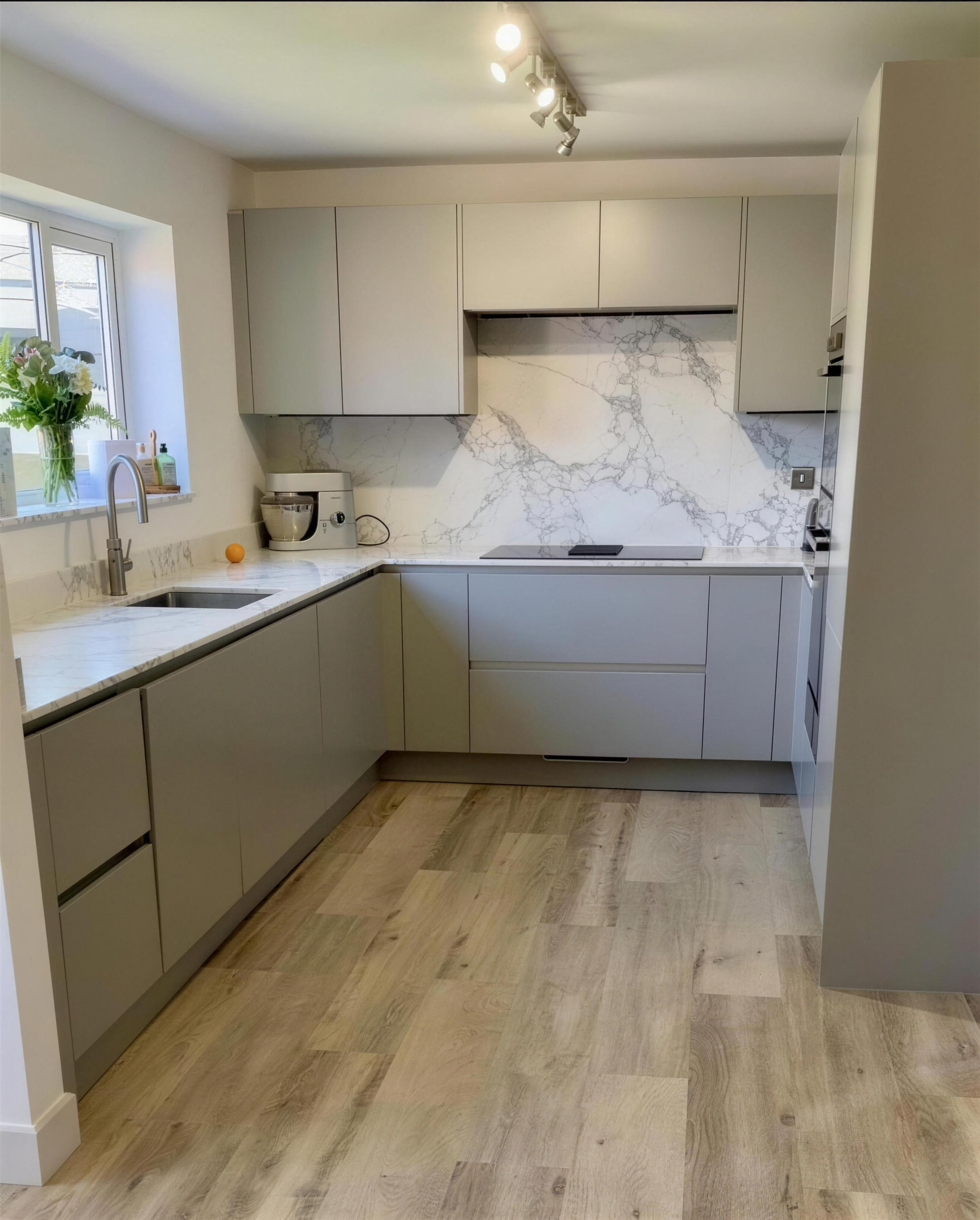 Grey handleless kitchen with marble splashback